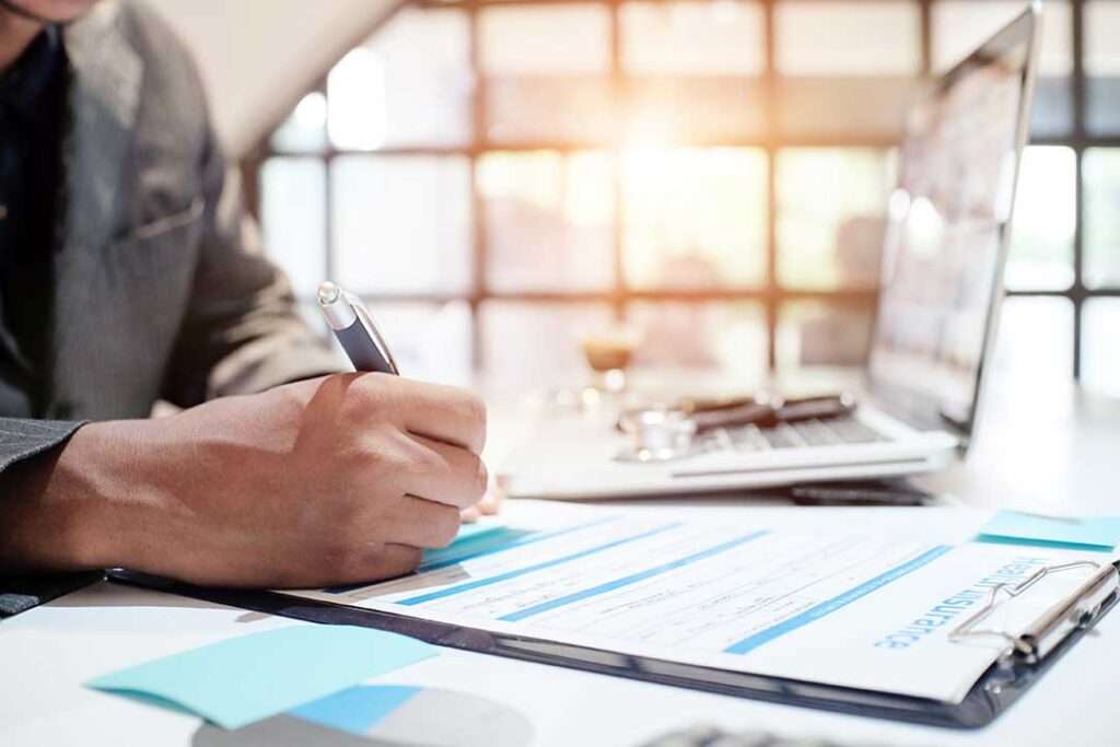 A woman discusses paperwork with a counselor in a comfortable office setting.